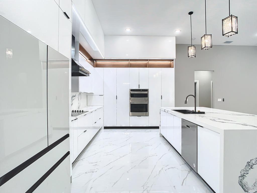 Cocina renovada con gabinetes blancos y electrodomésticos integrados