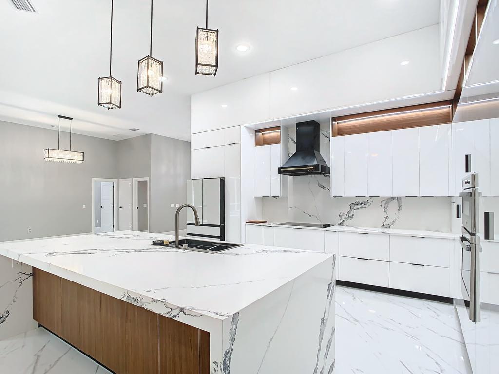 Cocina renovada con isla de acabado claro y detalles de madera